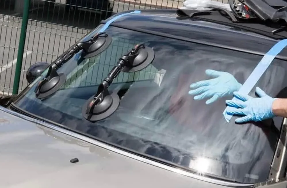 Parbriz poziționat cu ventuze, cu mâini în mănuși